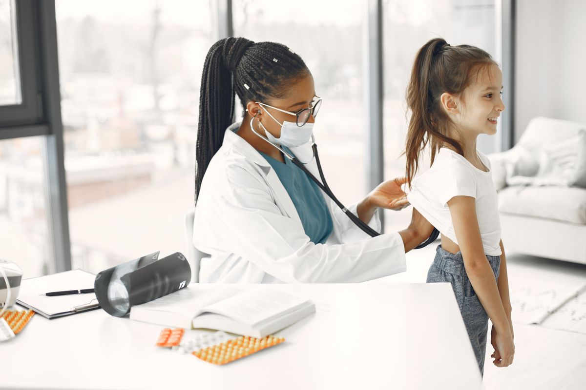 A physician caring for a young patient in her own clinic